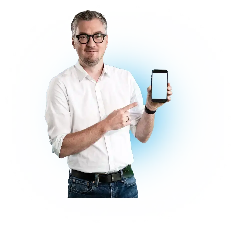 Un hombre con camisa blanca señala un smartphone con la pantalla en blanco.