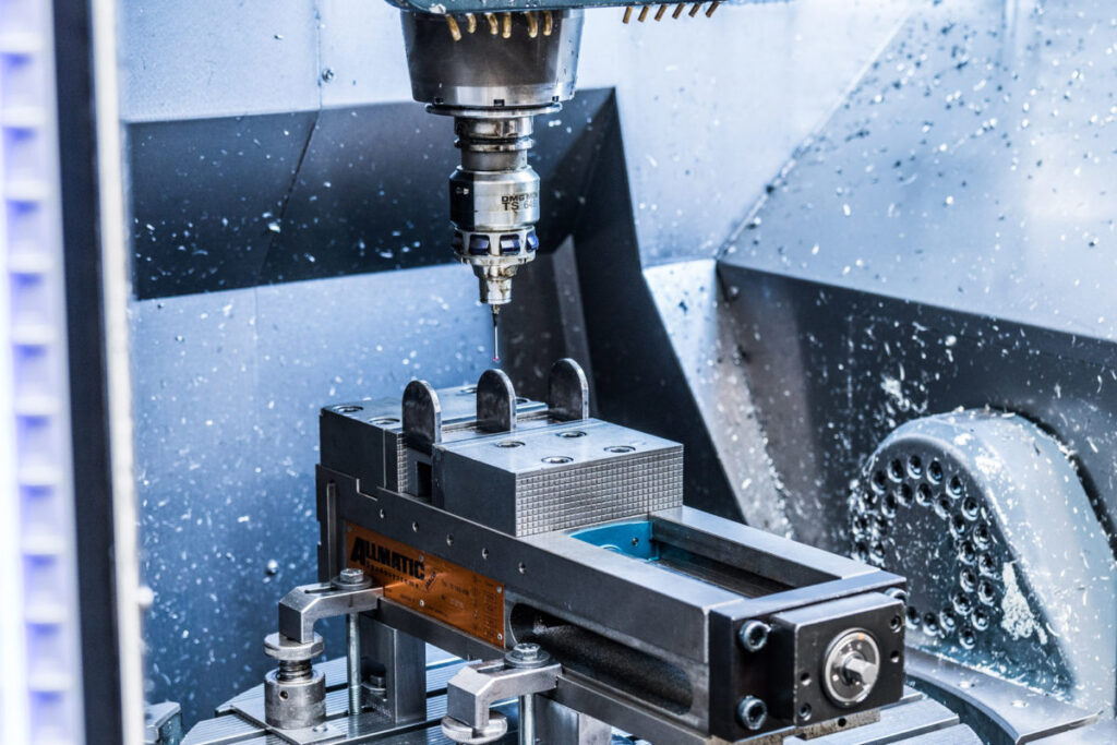 MECANIZADO CNC: Una fresadora mecaniza un bloque de metal en un taller.