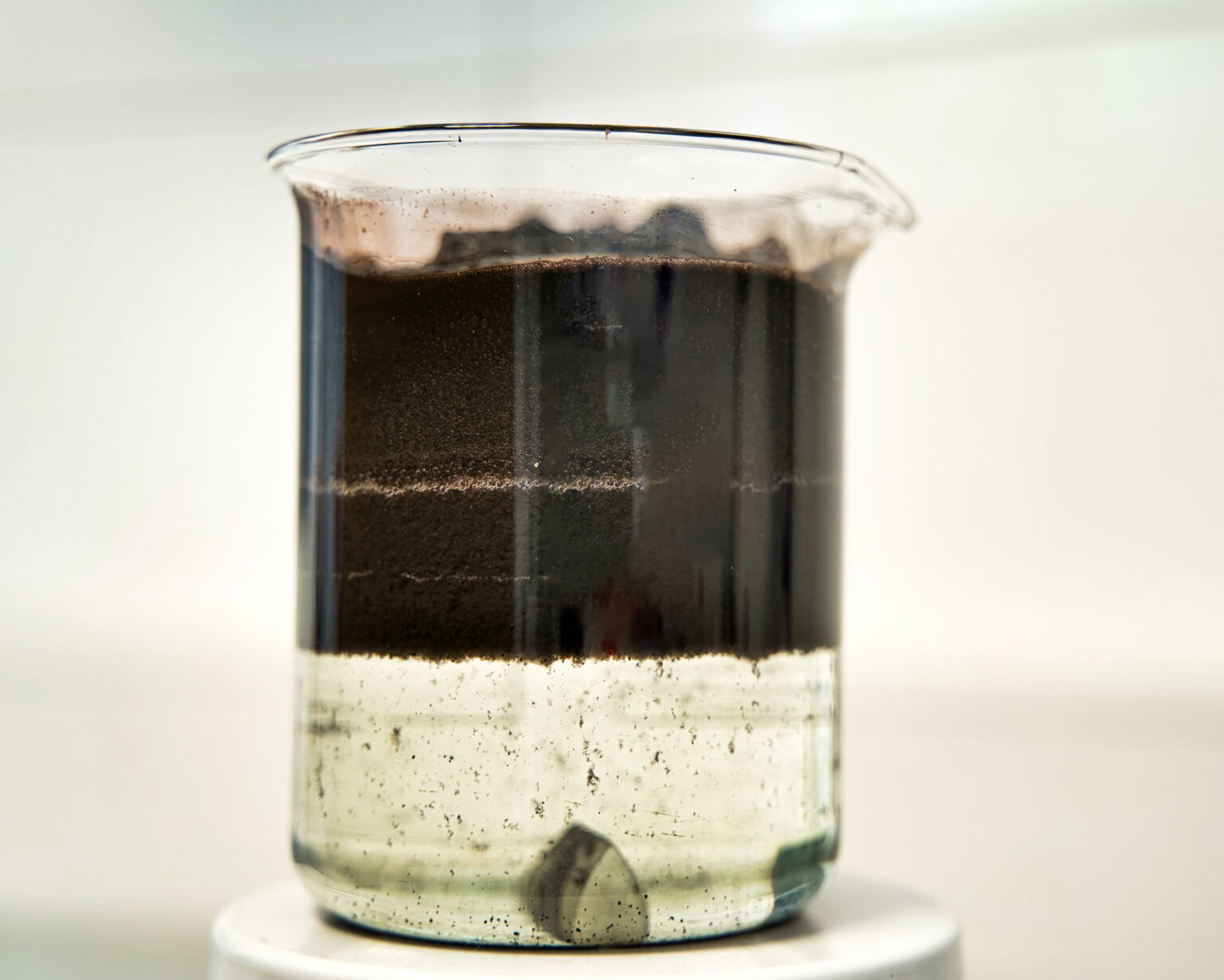 Muestra de aguas residuales procedentes de la industria del papel y la celulosa, en la que los contaminantes se sedimentan lentamente