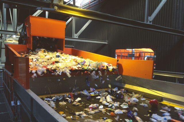La cinta transportadora oscilante envía el material reciclado de envases ligeros a una máquina clasificadora por infrarrojos (NIR). El material se distribuye uniformemente a lo largo de todo el ancho, lo que garantiza un suministro óptimo.