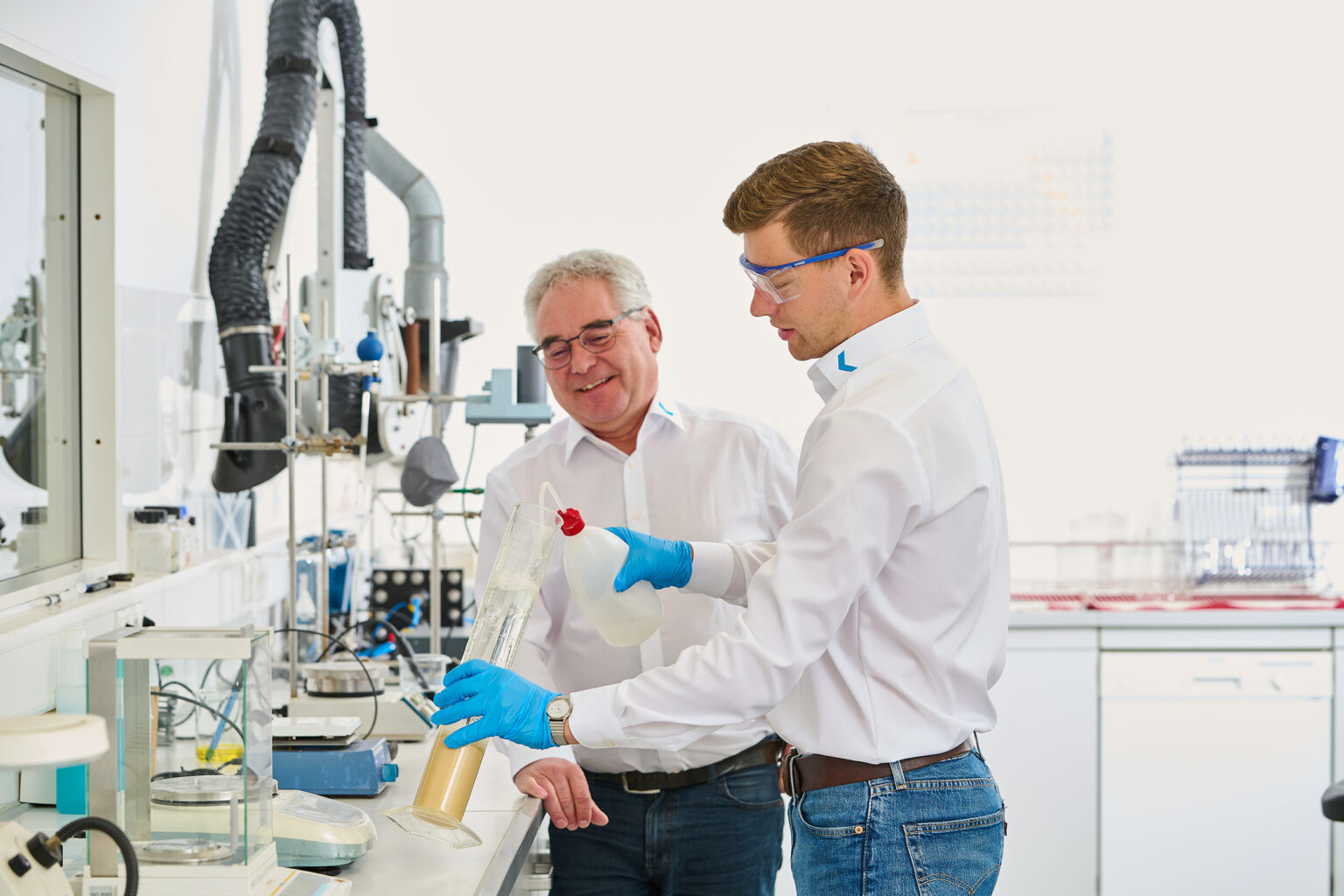 Dos hombres en un laboratorio que trabajan en un proyecto de tratamiento de agua.