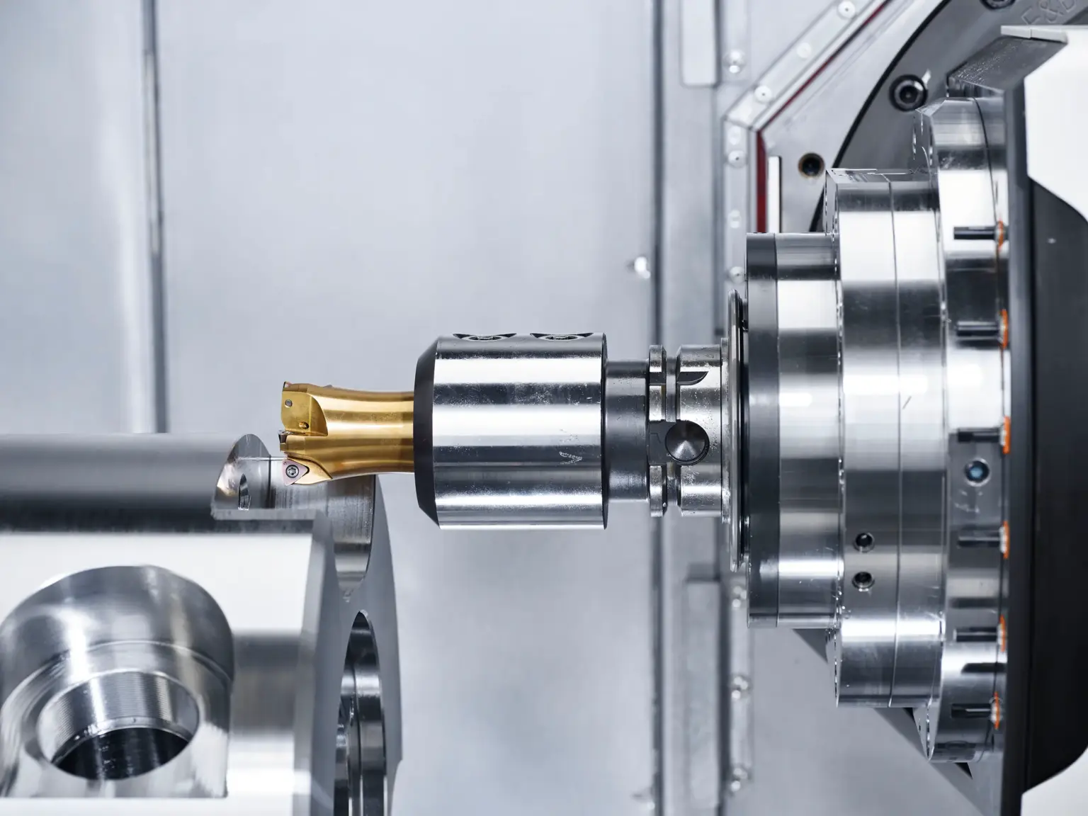 Una máquina CNC mecaniza un componente metálico, centrándose en piezas torneadas de precisión.