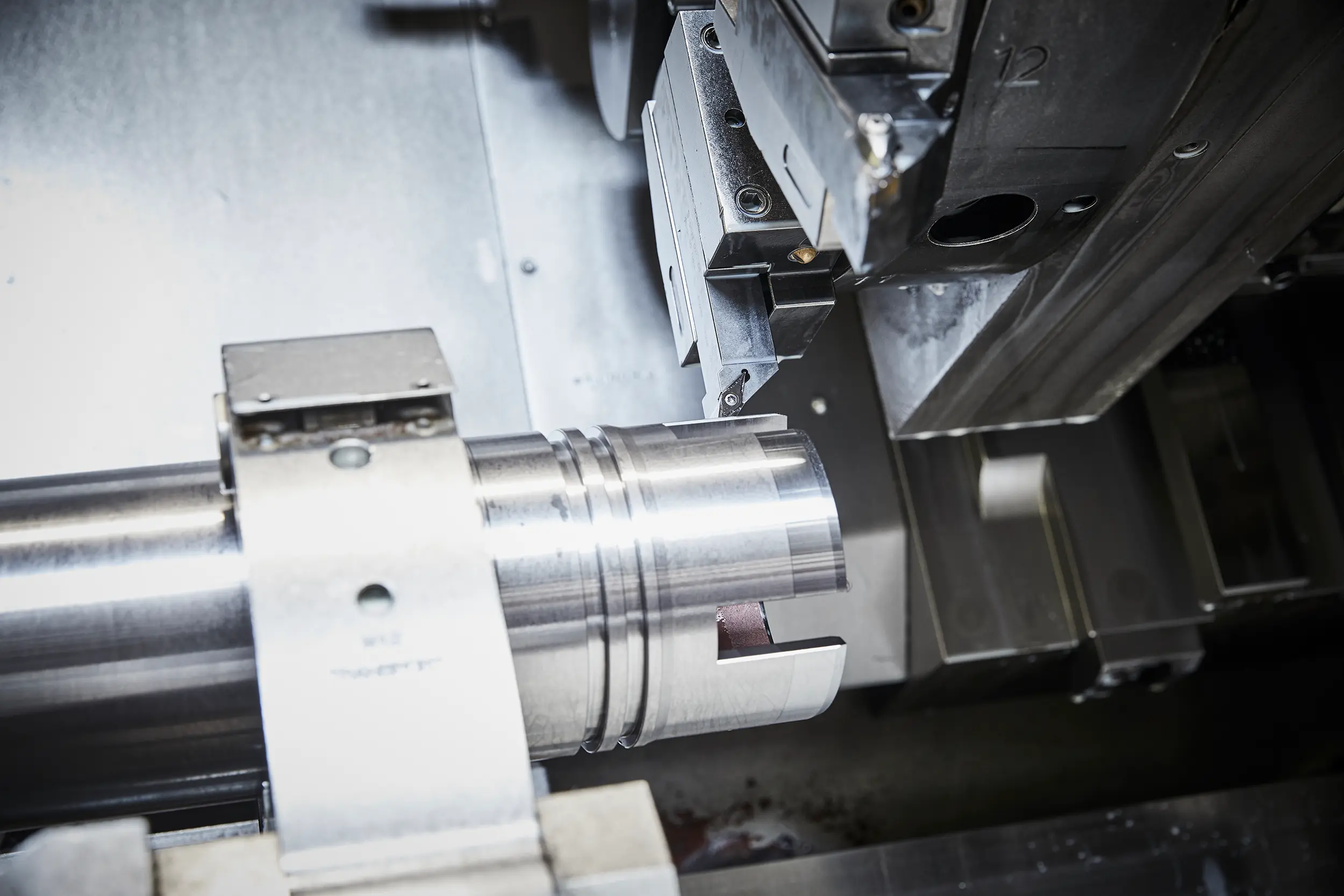 Imagen detallada de la fabricación de una pieza torneada con CNC en la empresa de subcontratación SPALECK; aquí se puede apreciar el interior del torno de última generación