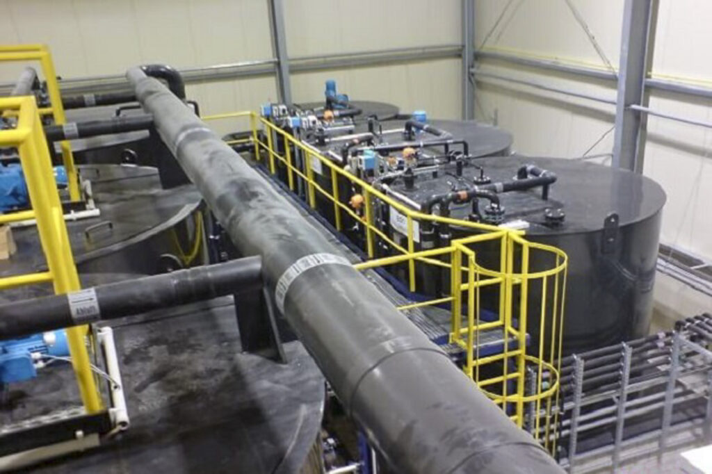 Instalación industrial para el tratamiento de agua de recirculación con grandes depósitos y tuberías.