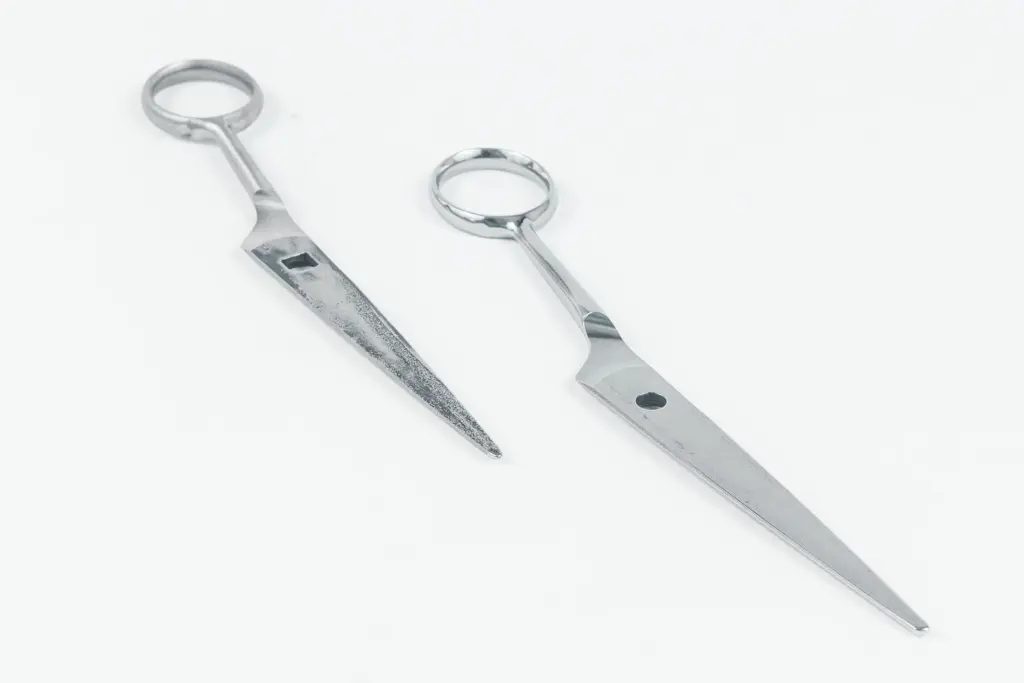 Dos herramientas metálicas pulidas con mango en forma de anillo sobre un fondo blanco.