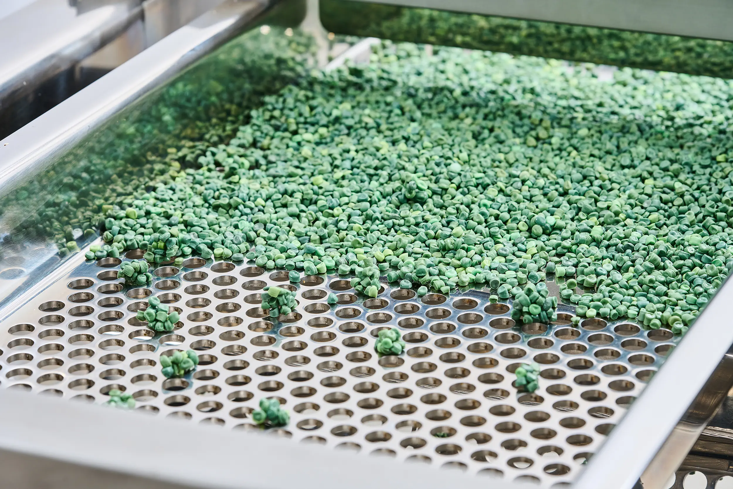 Granulado verde en una cribadora de granulado que permite una separación precisa.