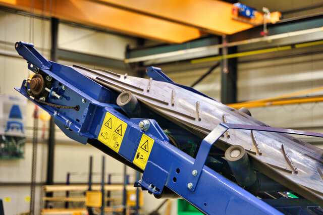 Detailansicht einer industriellen Maschine mit blauen Metallkomponenten.