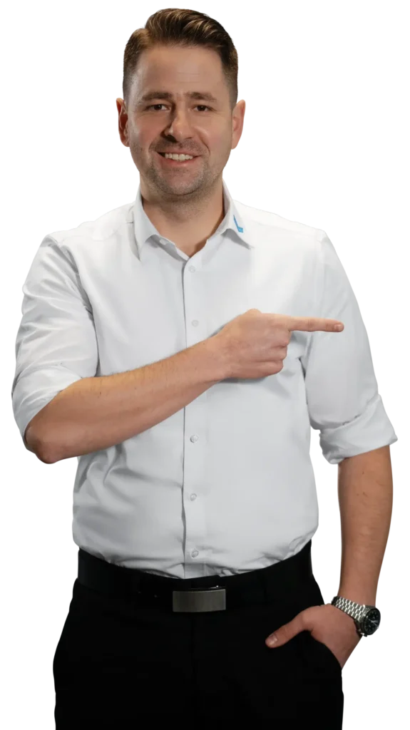 Un hombre con camisa blanca señala hacia la derecha; la imagen se centra en el trabajo con metales.