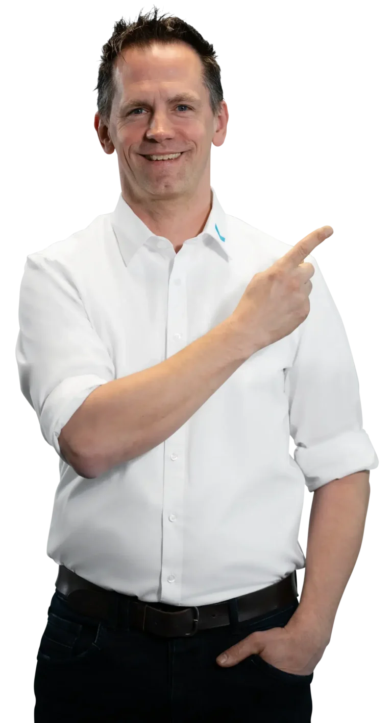 Un hombre con camisa blanca señala hacia un lado con una sonrisa.