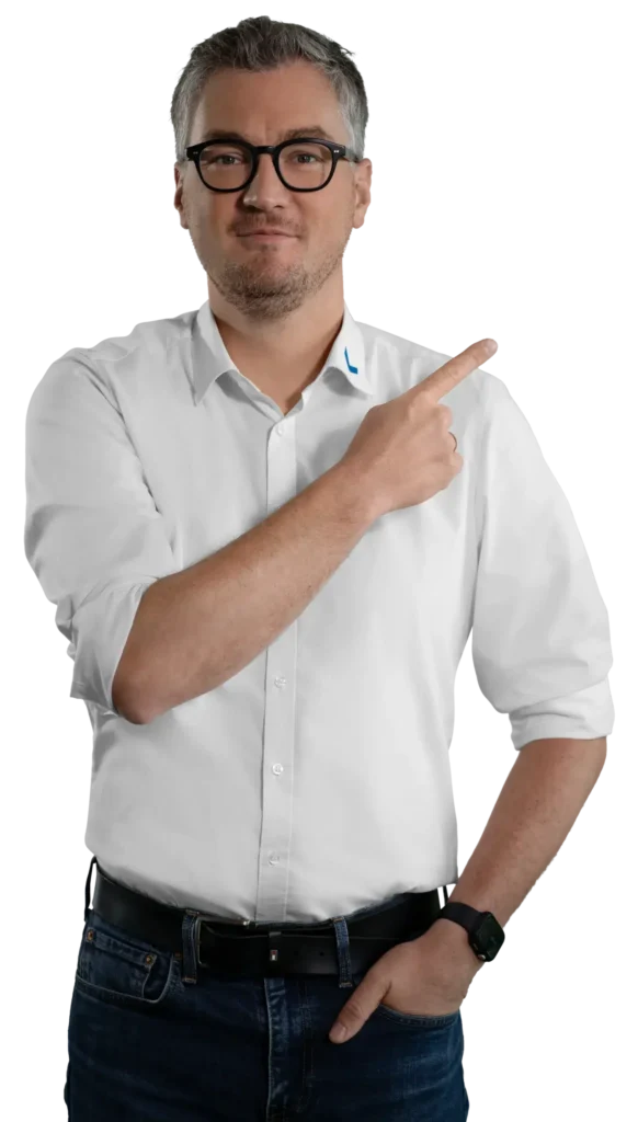 Un hombre con camisa blanca señala hacia un lado; es la persona de contacto.