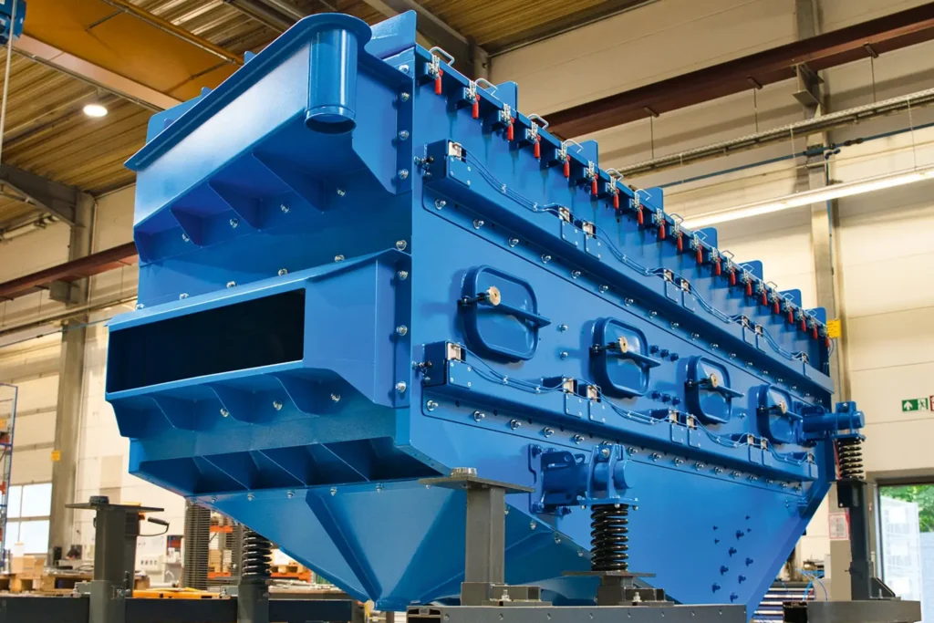 Gran máquina metálica azul situada en una nave industrial, adecuada para el TRATAMIENTO DE SUPERFICIES.