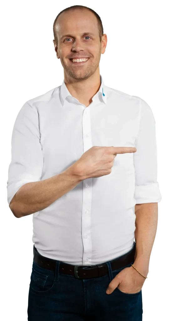 Un hombre con camisa blanca señala hacia la derecha, en el contexto del reciclaje de residuos electrónicos de «Immark».