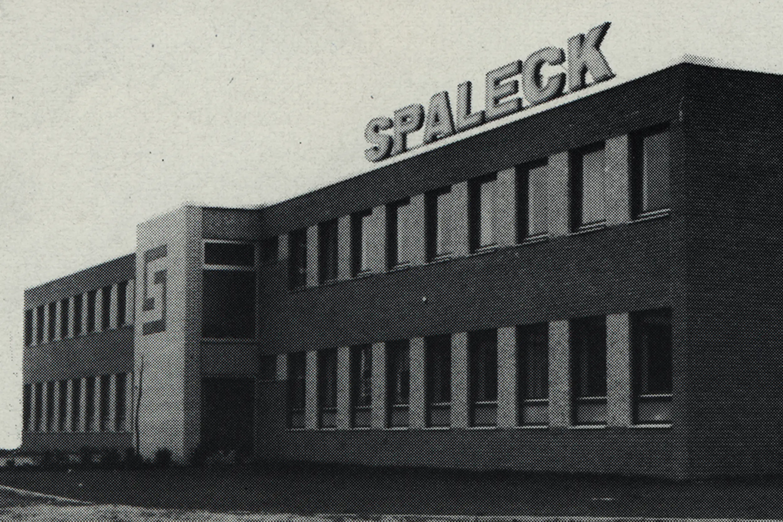 Zweistöckiges Gebäude mit großem 'SPALECK'-Schriftzug auf dem Dach.