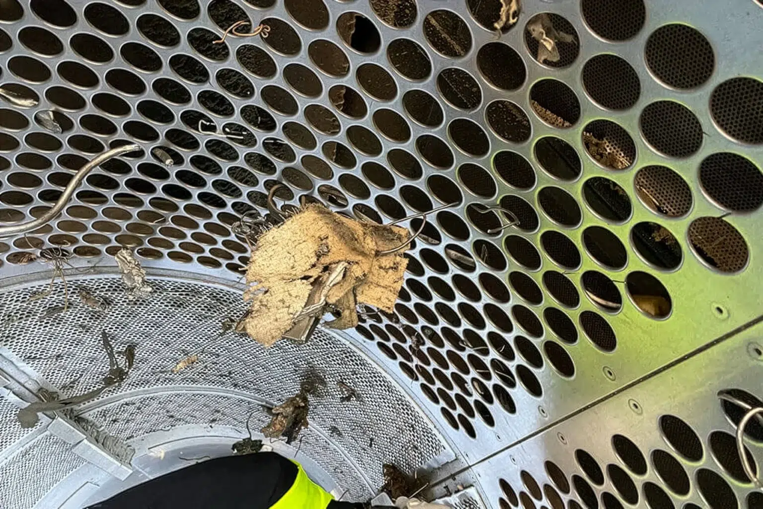 Vista detallada del interior de una cribadora de tambor. Se ve claramente que, al remover el material, pueden caer accidentalmente piezas largas en la fracción deseada.